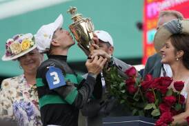 Brian Hernandez embraces the trophy after winning the Kentucky Derby on Mystik Dan. (AP PHOTO)