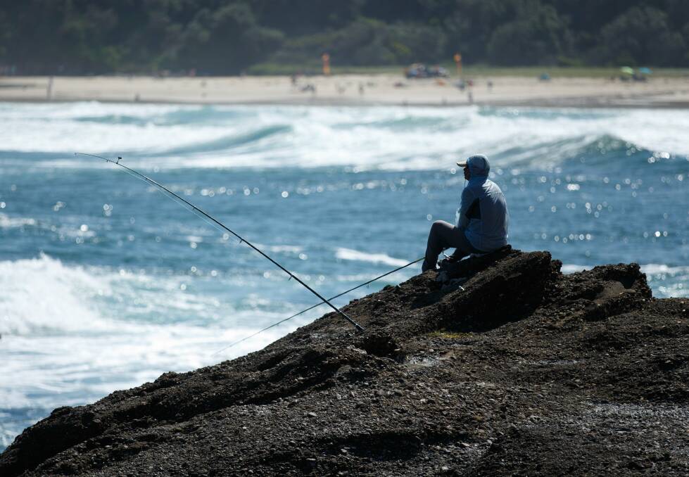 A rock fisherman at Snapper Point, near Catherine Hill Bay - a popular but notorious spot for coastal drownings and incidents.