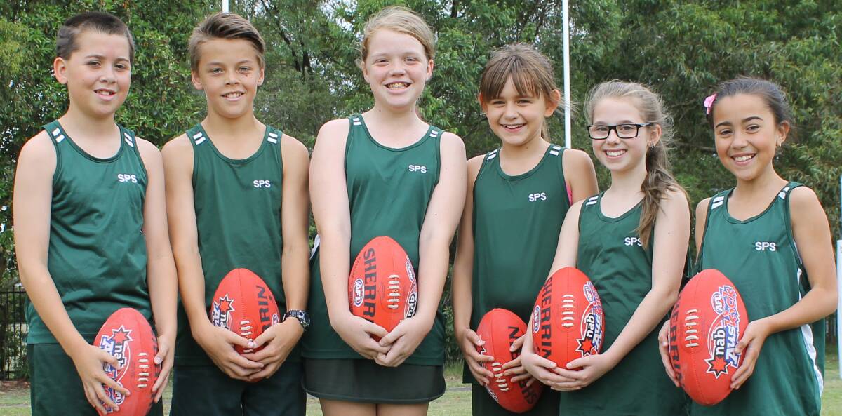 Active bunch: Shortland Public School students with the new footballs donated by AFL NSW, along with goal posts and protective pads. Picture: Georgia Osland