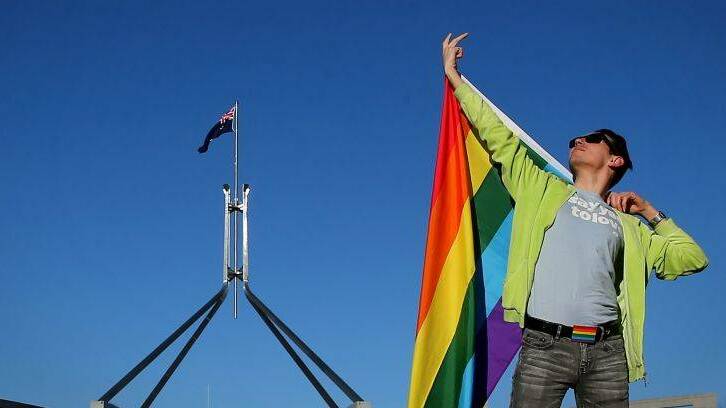 Marriage equality advocate Russell Nankervis poses for photographers with the rainbow flag during a 'Sea of Hearts' event in support of marriage equality on the front lawn of Parliament House in Canberra on Tuesday 8 August 2017. fedpol Photo: Alex Ellinghausen