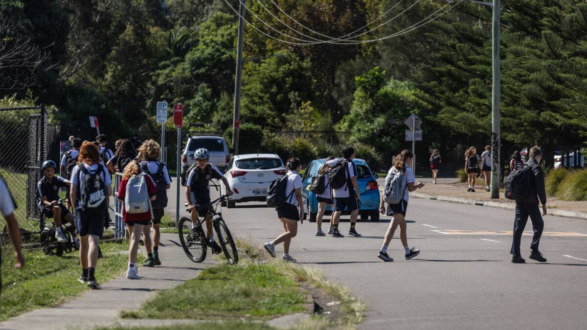 Newcastle High students crossing Smith Street on Monday after school. Picture by Marina Neil