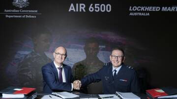 Chief Executive Officer, Lockheed Martin Australia, Mr Warren McDonald (left) and Head Air Defence and Space Systems Division, Air Vice-Marshal David Scheul, shake hands, following the signing of the Head of Agreement contract with Defence and Lockheed Martin Australia, that will deliver the Australian Defence Forces Joint Air Battle Management System (JABMS).