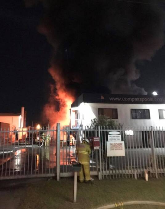 BUSINESS AS USUAL: Up to 20 fire crews contained a large blaze at Compass Pools at Tomago on Friday night to one stores shed. Picture: Raymond Terrace Fire and Rescue.