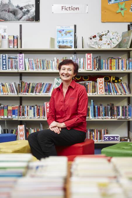 WELL READ: Robin Balcomb in the library at Mannering Park Public School. Picture: Supplied