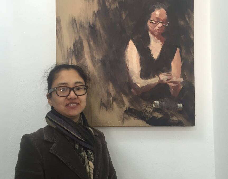 PASSION FOR ART: Ahn Wells stands beside a portrait of herself painted by Pablo Tapia, currently on exhibit at Gallery 139.