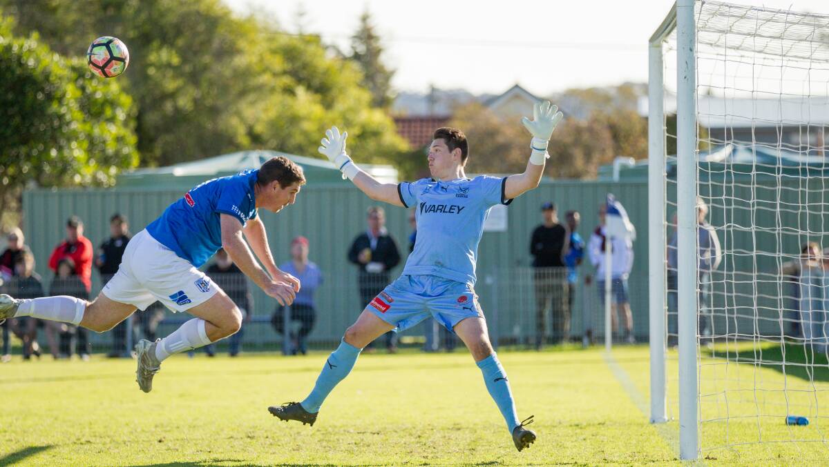 Edgeworth keeper Nate Cavaliere attempts to stop a header from Hamilton's Kane Goodchild in NNSW NPL.