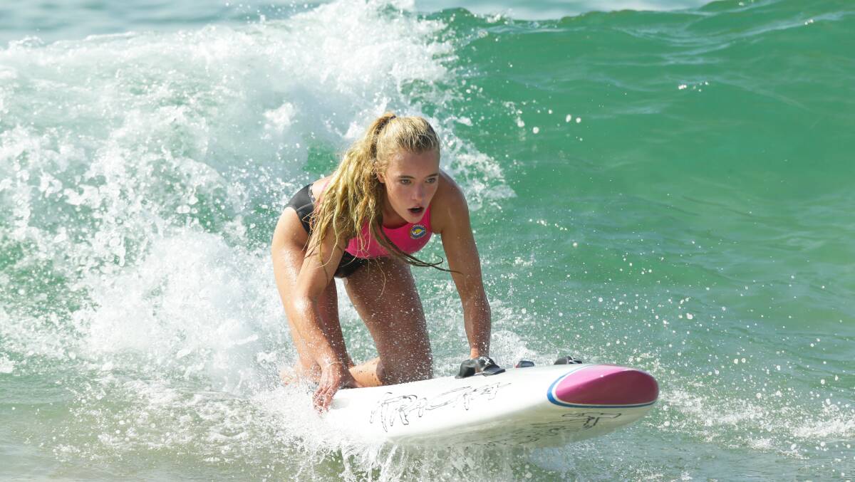 Lily Fletcher catches a wave during the Hunter Branch Surf Life Saving titles.