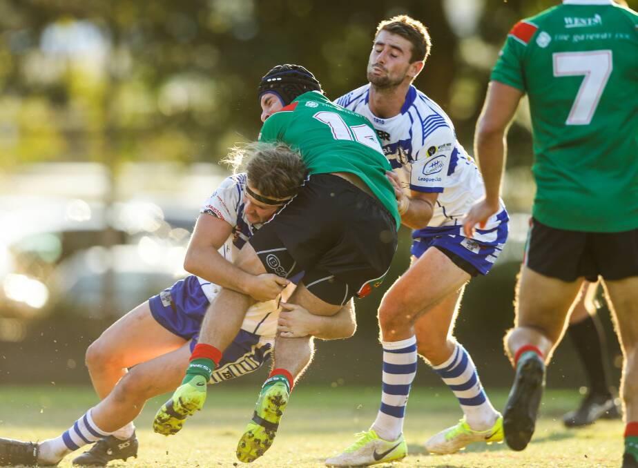 Wests player Chris Knight gets tackled by Central players Boyce Kennedy, left, and Nathan Taylor, right.
