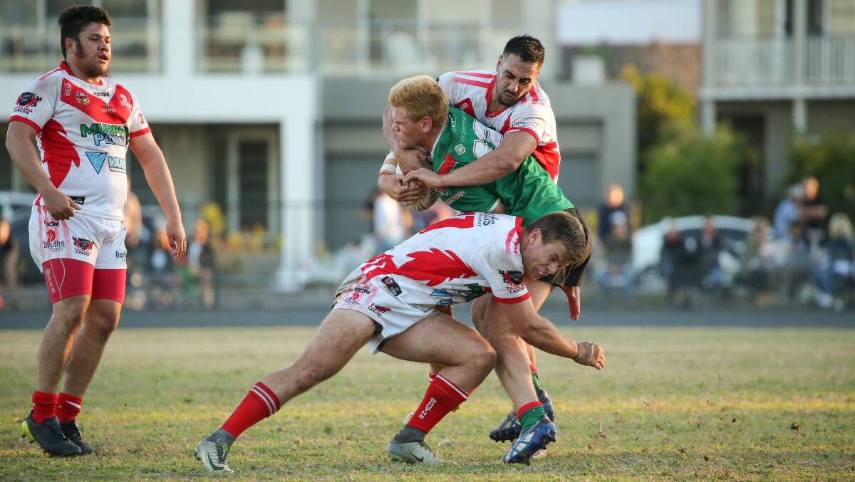 Souths players Brendon Simpson (back) and Jack Welsh tackle Wests' Ben Stone at Townson Oval.