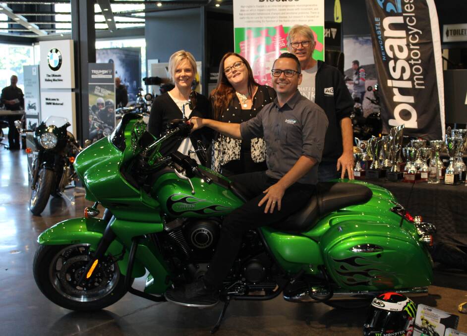 AWARENESS: The Kawasaki Vulcan 1700 Vaquero to be raffled off to raise funds for Huntington's NSW. Wallsend's Brittani Faulkner, middle, lost her father to the disease.
