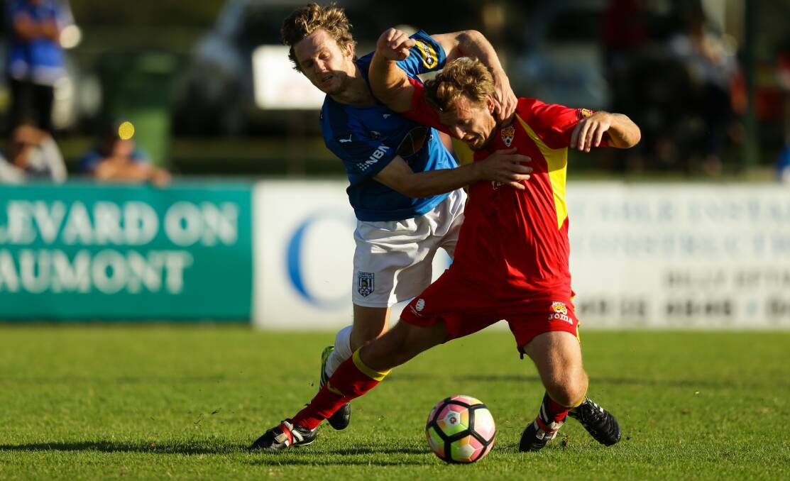 Broadmeadow's Shane Paul, in red, and Olympic's Daniel Bird tussle.