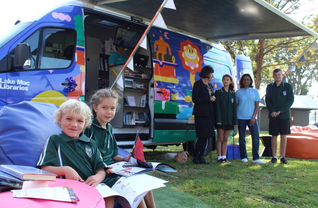 APPROVAL: Valentine Public School students Koby Wolfenden and Sophia Martini get into some reading as Lake Mac Libraries show off their new 'Rover'.