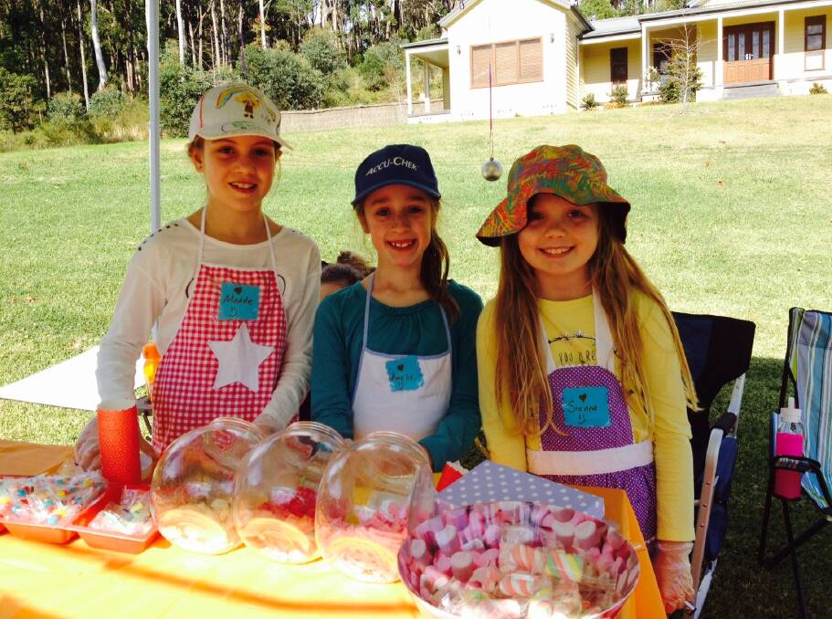 KINDNESS: Madeline Mitchell, Amelia Scully and Sienna Eve at their Tingira Heights lolly and cake stall.