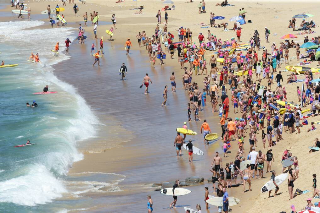 SAFETY: In a familiar scene on the region's beaches throughout this summer, swimmers and nippers leave the water at Bar Beach after the shark alarm was sounded on Sunday.
