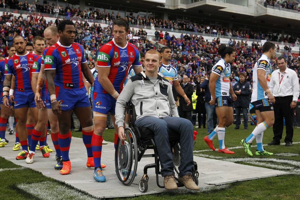 HOME: Newcastle Knights skipper Kurt Gidley wheels injured teammate Alex McKinnon onto the field at Hunter Stadium.