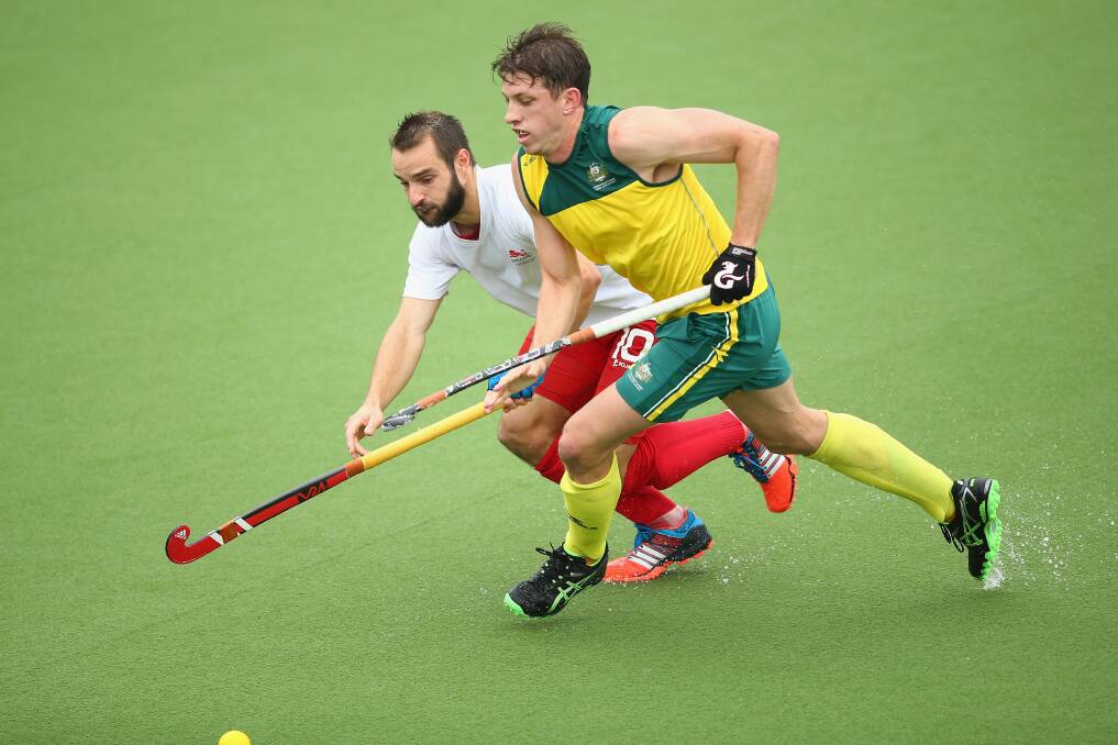 GOLD RUSH: Simon Orchard battles for the ball with during the men's semi-final match between Australia and England. The Kookaburras won this game and went on to win gold against India. Picture: Getty Images