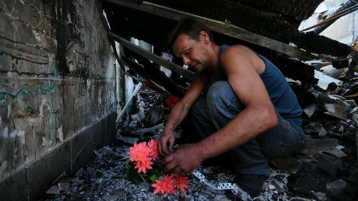 Dimitriy Gorozhaninov sits inside the remains of his family's home where his father, mother, sister and wife died after a shell landed on their home in Petrovskiy on the outskirts of Donetsk.  Photo: Kate Geraghty