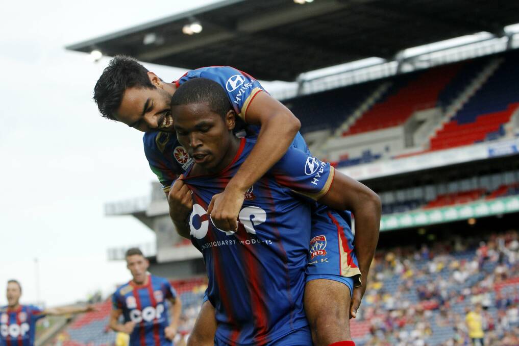SHOT: The Newcastle Jets' Edson Montano (bottom) and Marcos Flores celebrate Montano's goal against the Central Coast Mariners.