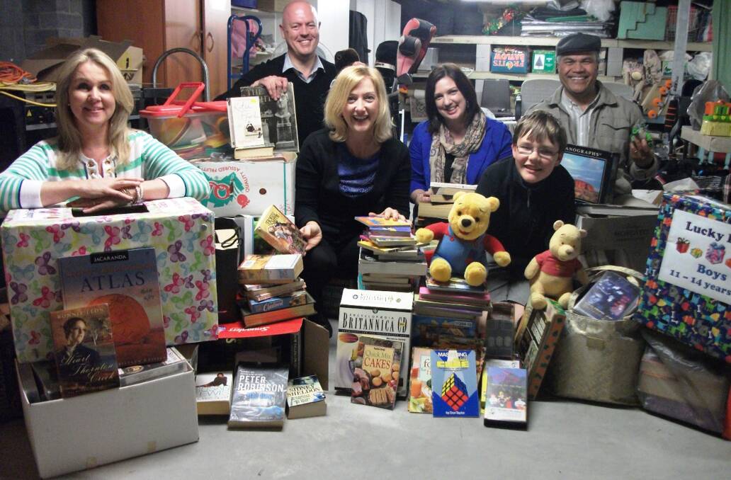 St Luke's Uniting Church volunteers with books and toys to be sold at the church's annual carnival.