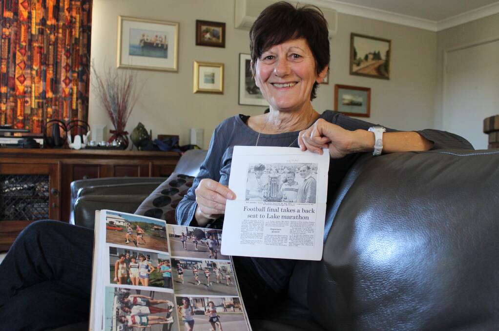Lake Macquarie Running Festival participant Janice Davis holds the Herald article published when she won the half marathon in 1985.
