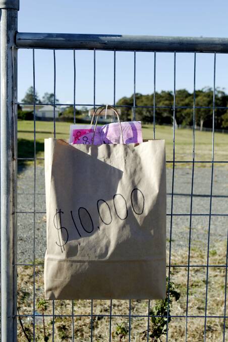 OPPOSED: Brown paper bags hang on the fence around the proposed Whitebridge development.
