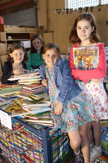 Kymberlie (11), Victoria (11), Laura (9) and Issabella (7) Johnston, from Georgetown, sort through the books at Lifeline's warehouse at Hamilton North.