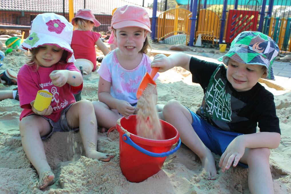 SAFE AND SANDY: Emily Knott, 3, Olivia Carlyle, 4, and Travis Packer, 4, play in the new sandpit at Macquarie Hills Community Preschool.