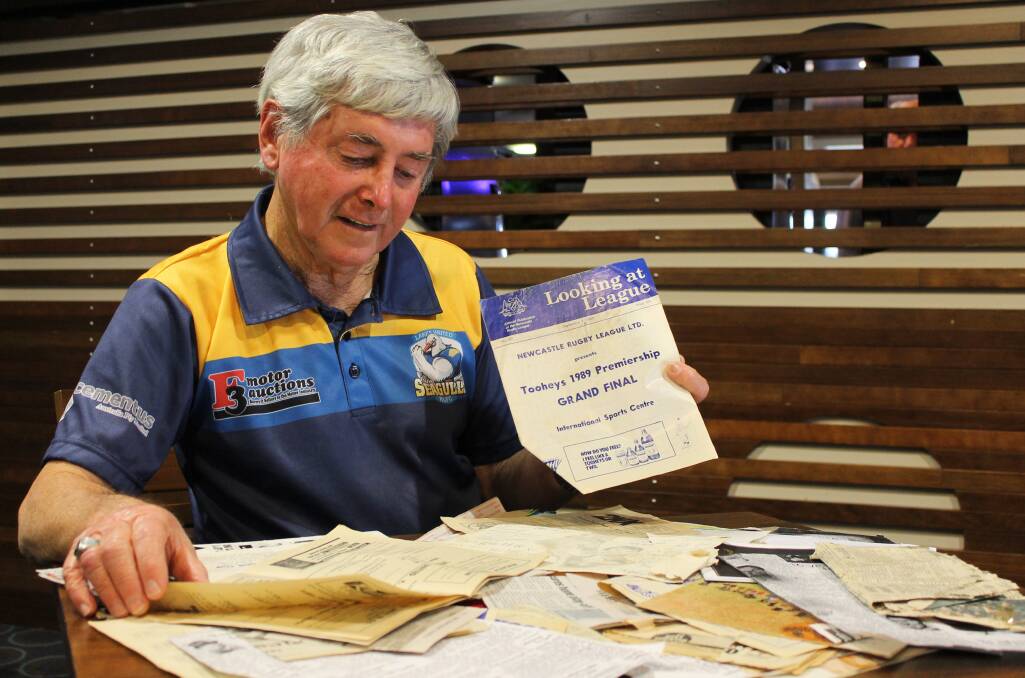 MUSING: Windale’s Lester McDonald sifts fondly through the Lakes United Football Club memorabilia he has collected over the years.