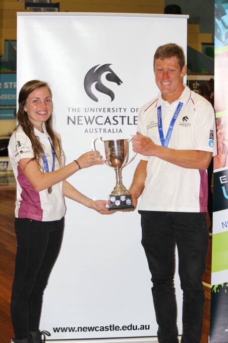 University of Newcastle team captains Christine Brady and Chris Hill accept the institution's trophy for the 2014 Eastern University Games.