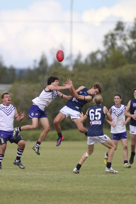 Lake Macquarie's Damon Barry leaps high to contest possession against Newcastle City, while his Dockers team-mates Brad Farrell, left, and Tim Wells wait for the crumbs.