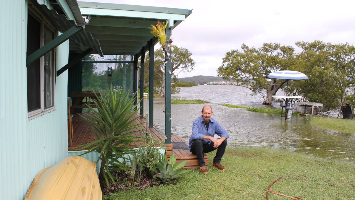 Jason Jackson outside his Little Pelican home as flood waters recede on Wednesday.