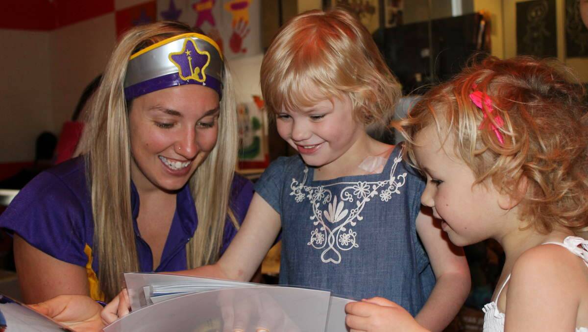 BRIGHT MOMENTS: Captain Starlight with Victoria Robinson, 5, and her sister Alexandra, 4, look at photographs from Victoria's snow trip.