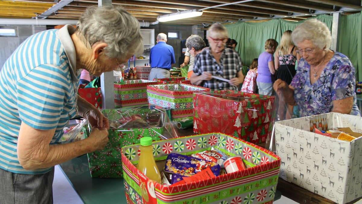 HELPERS: St Luke’s Uniting Church Community Commission volunteers pack hampers to distribute for Project Blessing. Volunteers Rosemary Doust, of Blacksmiths, and Joan McGoldrick, of Belmont.