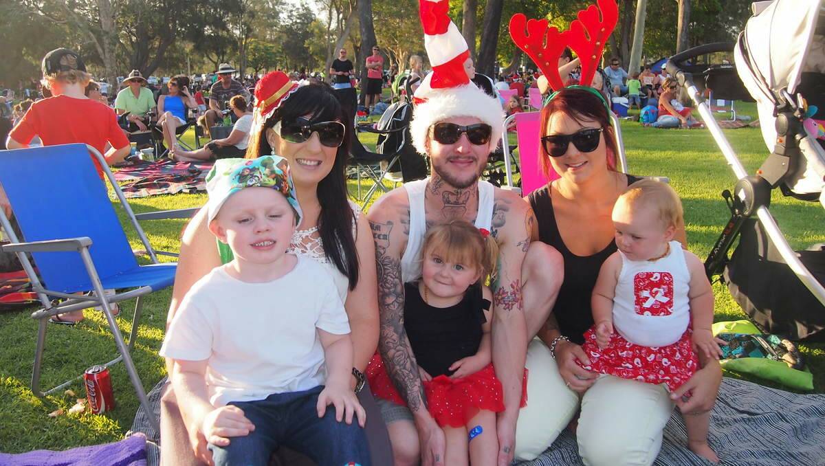 Bec Labry of East Maitland holds her daughter Jet with Brendan and Jade Laughlan of Lambton with their daughter Aleah-Jade, 2, and Georgia, 10 months at Newcastle Permanent annual Carols By Candlelight, Speers Point Park.