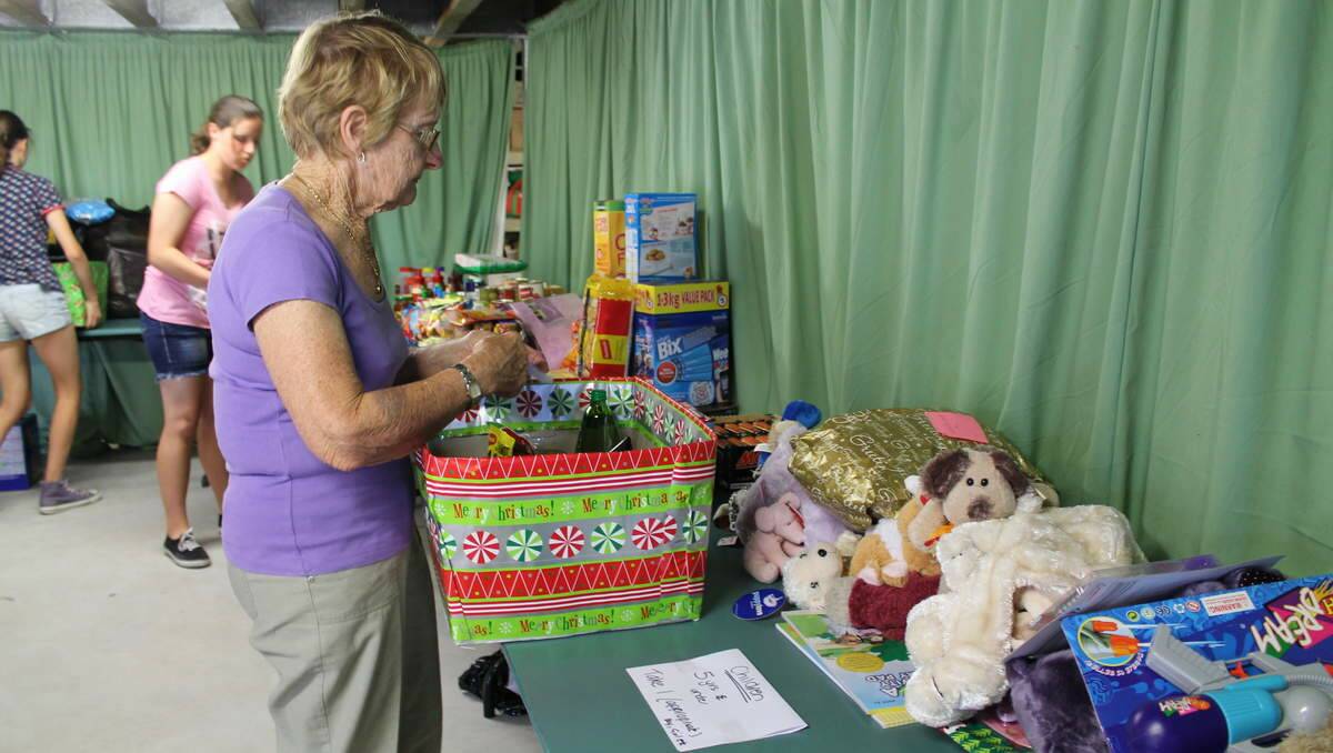 HELPERS: St Luke’s Uniting Church Community Commission volunteers pack hampers to distribute for Project Blessing. Volunteer Bev Hotwood, of Eleebana.