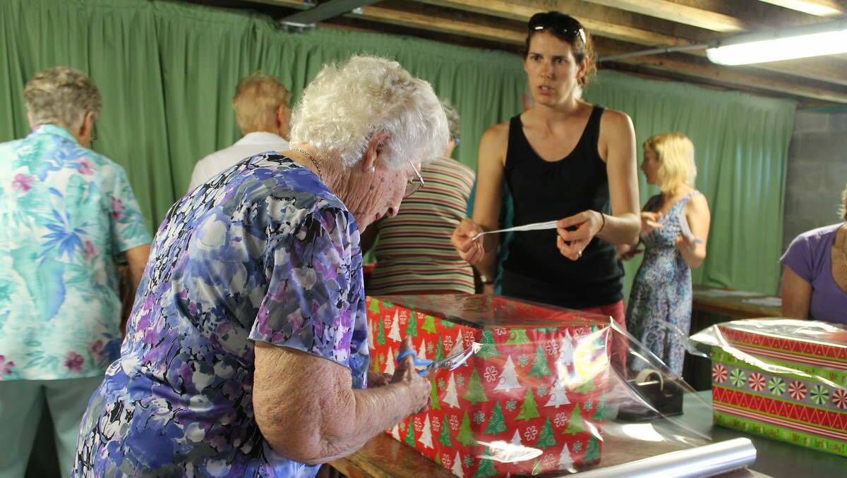 HELPERS: St Luke’s Uniting Church Community Commission volunteers pack hampers to distribute for Project Blessing. Volunteer Joan McGoldrich, of Belmont.
