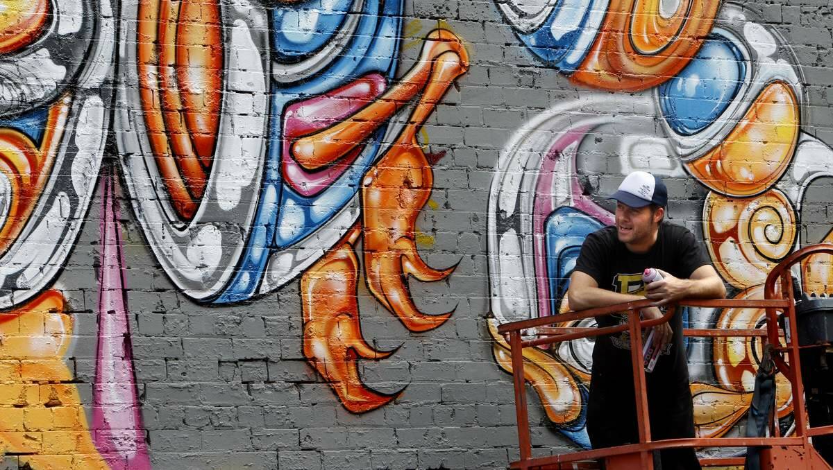 PROGRESS: Street artist Tim Phibs works on his mural at Balance Gym, Hunter Street.