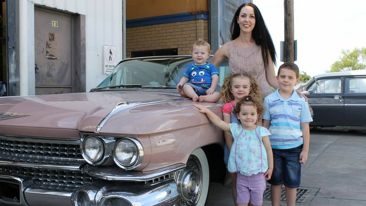 Bianca Judd and her children Jimmy, 11 months, Ruby, 4, Jessie, 6, and Lilly, 2, next to Stella - a 1959 restored Cadillac Coupe.