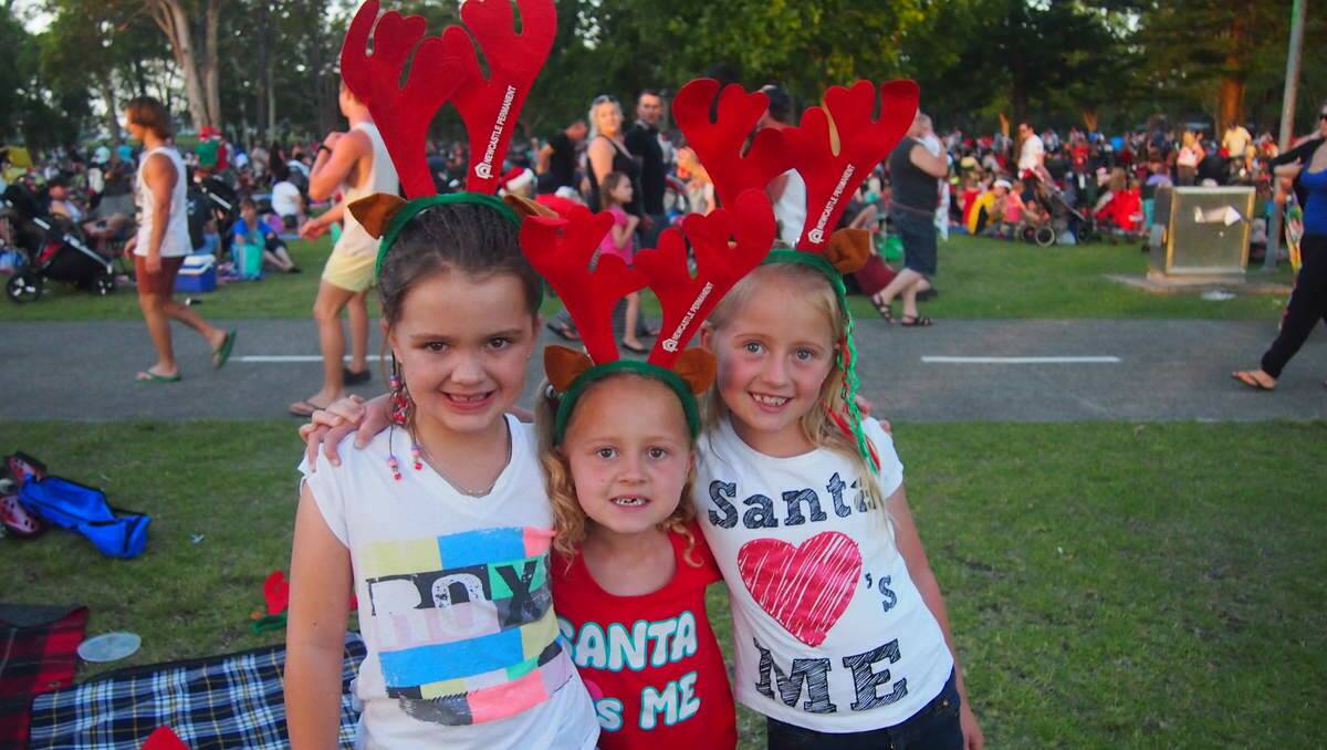 Waiting for Santa to arrive are Olivia O’Brien, 7, of Waratah West, with Glendale sisters Makenna and Taneisha-Kee Fry, 6 and 9.