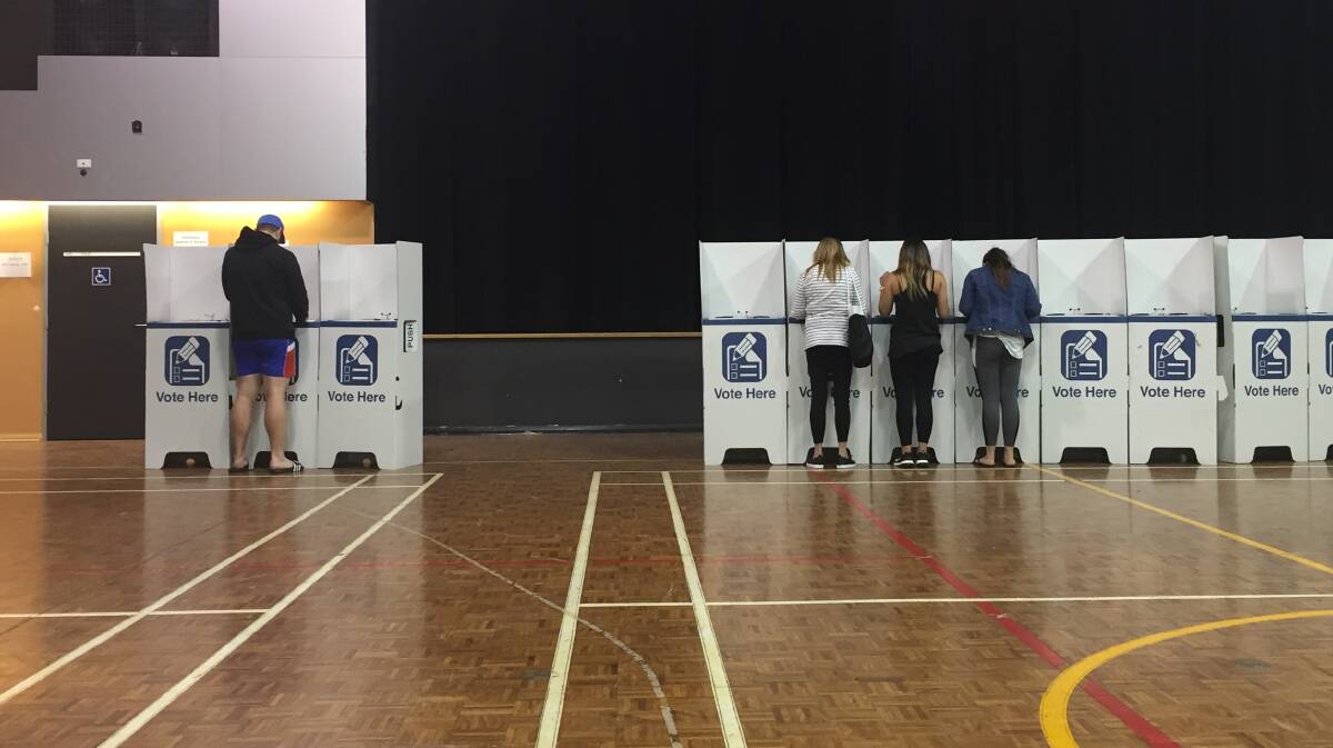 Voters sneak in as the clock ticks towards closing time at the Callaghan College booth.