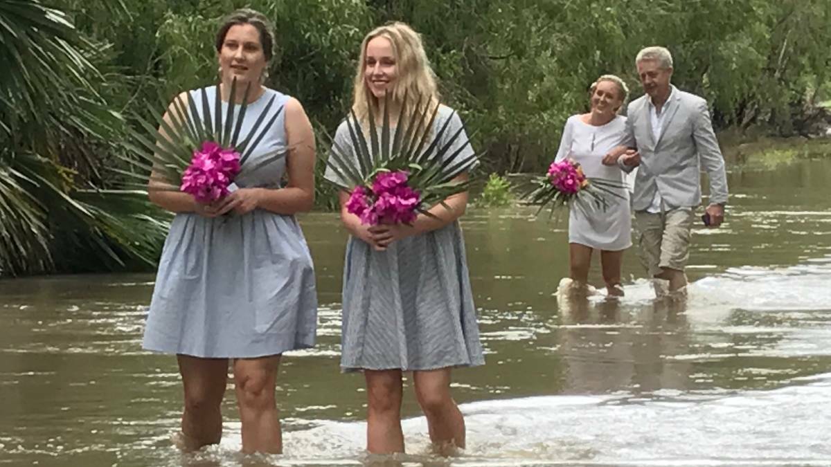 FLOODED WEDDING: Bridesmaids lead the way down an unconventional aisle, commonly called the Little Roper River, while the bride and her father follow. Picture: supplied.
