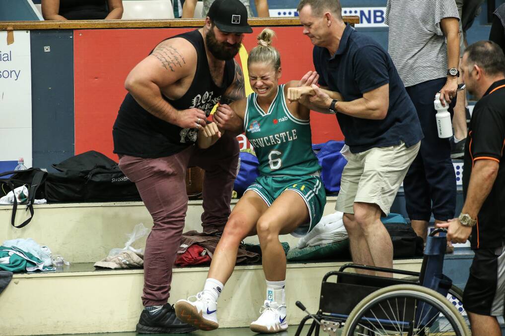 DOWN BUT NOT OUT: Cassidy McLean is assisted from the court five after damaging her knee. Pictures: Marina Neil 