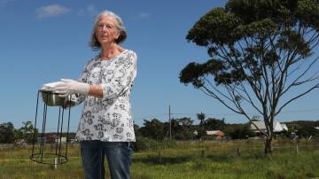 Cabbage Tree Road resident Jenny Robinson with a University of Queensland PFAS air monitor. Picture by Peter Lorimer.