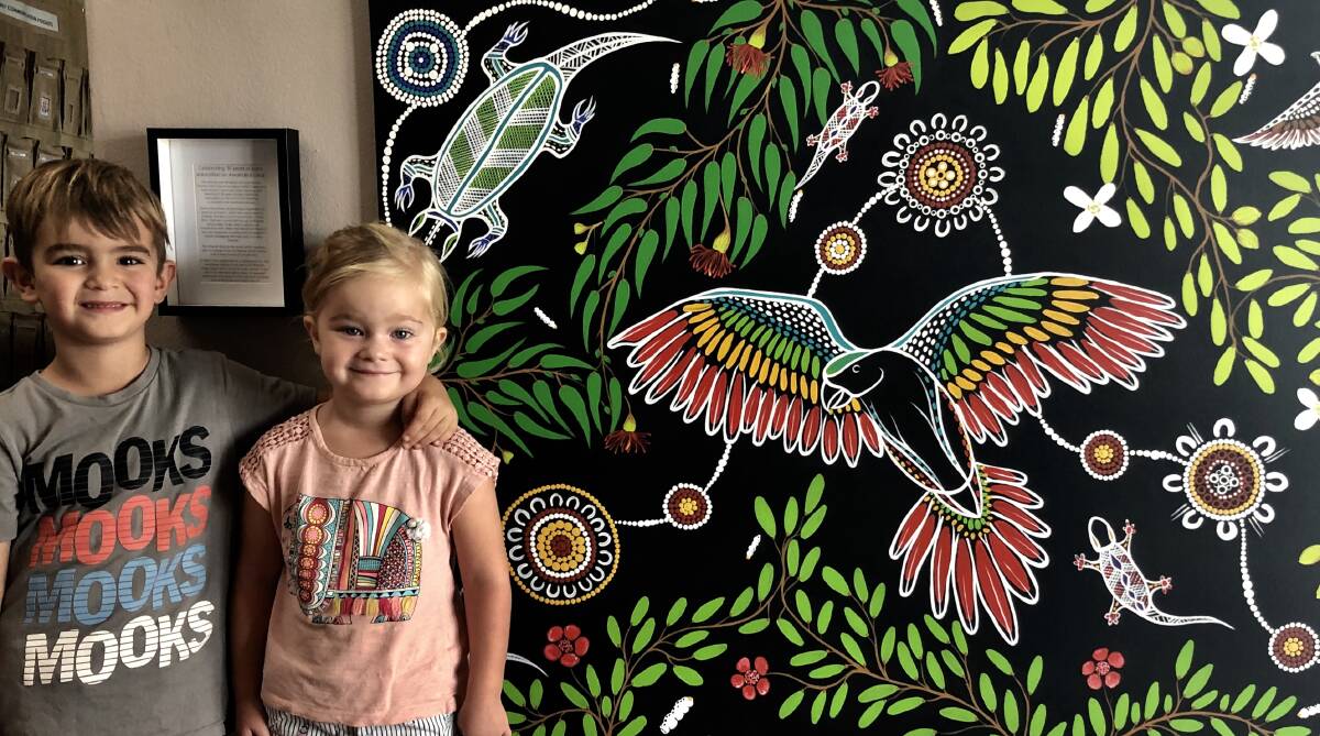 LEARNING CULTURE: Xander Haines and Rose Andoni stand with a work by Thomas Croft which hangs at Adamstown Community Learning and Preschool.  Picture: supplied