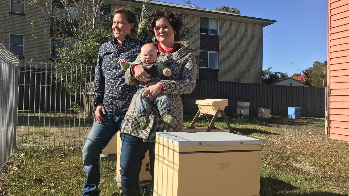 SWEET STUFF: Kelly Lees, left, pictured at the Mayfield apiary with partner Anna Scobie and daughter Nancy, 4 months. Picture: Melinda McMillan