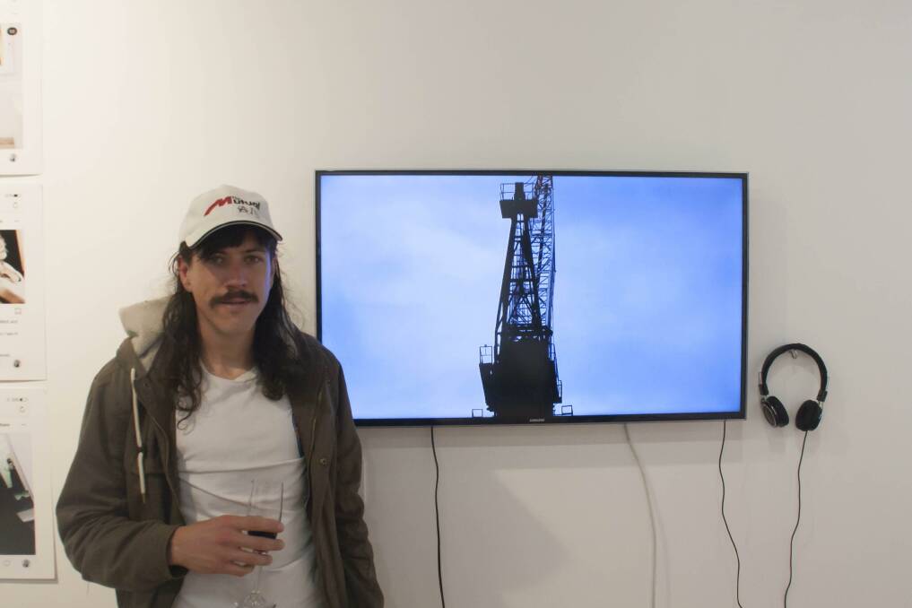 ANGSTY WORK: Tim Buchanan stands with a still from his rap and slam-poetry video titled Dust on Dust. Picture: supplied