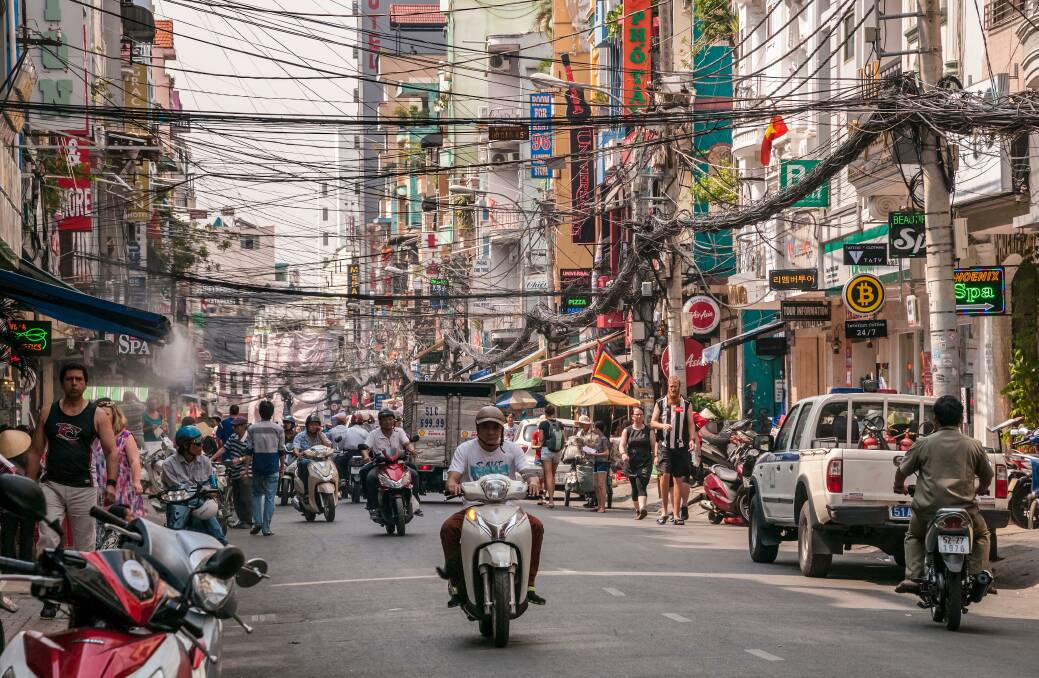 Millions of motorbikes ferry the locals around Ho Chi Minh City, where the twisted and tangled power lines offer a good visual metaphor of the city's organised chaos. Picture: Alamy