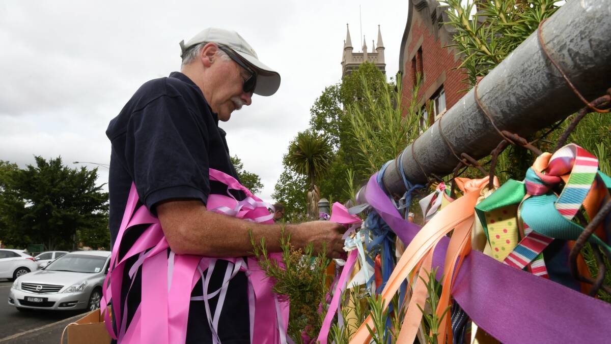 Volunteers place thousands of new ribbons on the St Alipius 'loud fence' on Saturday. Picture: Lachlan Bence
