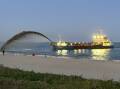 A dredge spraying sand at Stockton beach on Saturday. Picture by Simon Herd