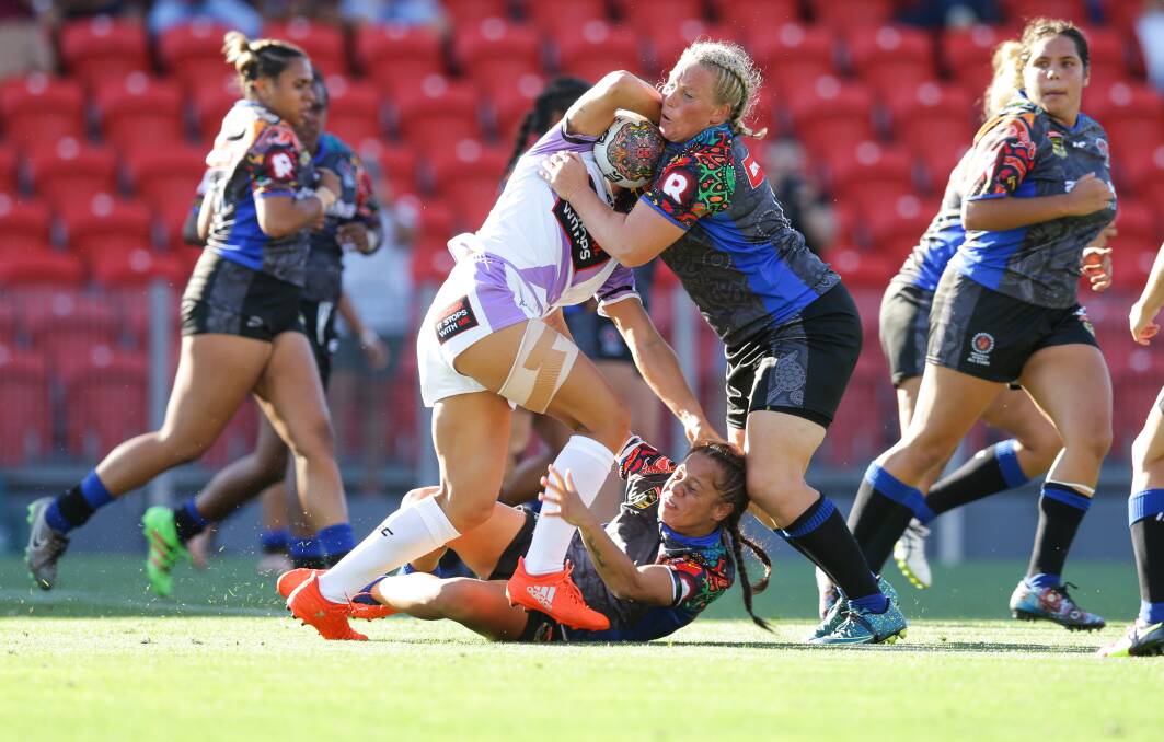 HEAD-TURNER: Bec Young, right, and Isabelle Kelly, left, make a tackle for the Indigenous All Stars at McDonald Jones Stadium in February. Both will represent NSW against Queensland on July 23. Picture: Jonathan Carroll